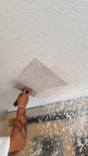 Hand finishing a textured ceiling.